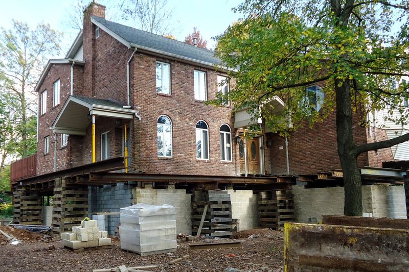 In a flood zone, this house in Cranford, New Jersey, has been raised up with I-beams, and now cinder blocks are added beneath it, so when it